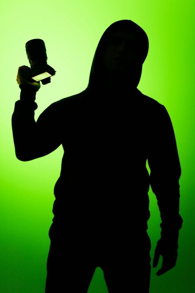 pexels-photo-1799910-1799910 Silhouette of a person holding a camera against a vibrant green background.